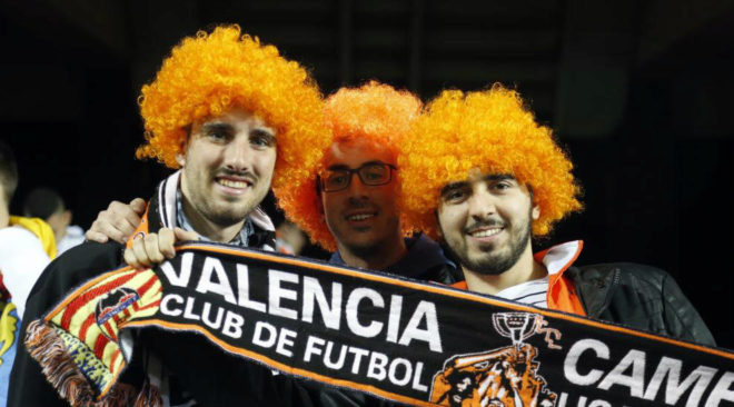 Varios aficiondos con pelucas naranjas en Mestalla.