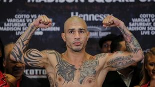El boxeador puertorriqueo Miguel Cotto alza los brazos durante la...