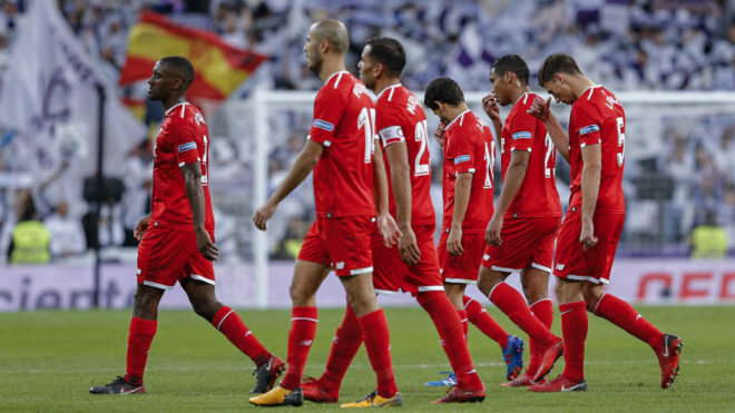 Los jugadores del Sevilla se retiran cabizbajos al descanso.