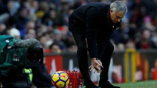 Mourinho trata de coger un baln que se le cuela entre las piernas.