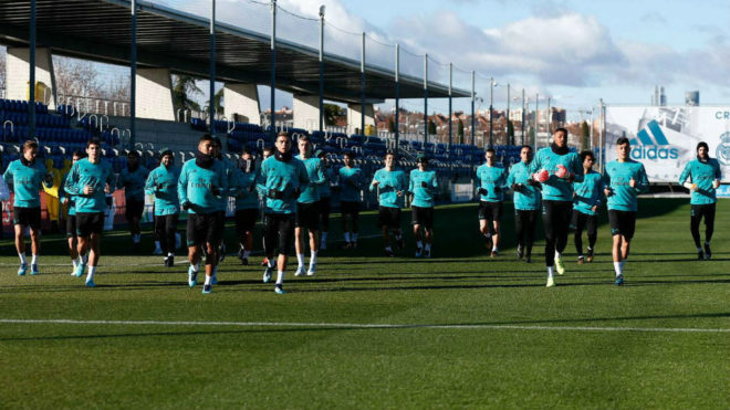 Los jugadores del Madrid corren sobre el csped de Valdebebas