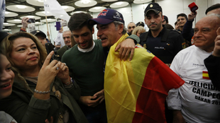 Sainz, con la bandera espaola, abrazado por su hijo.