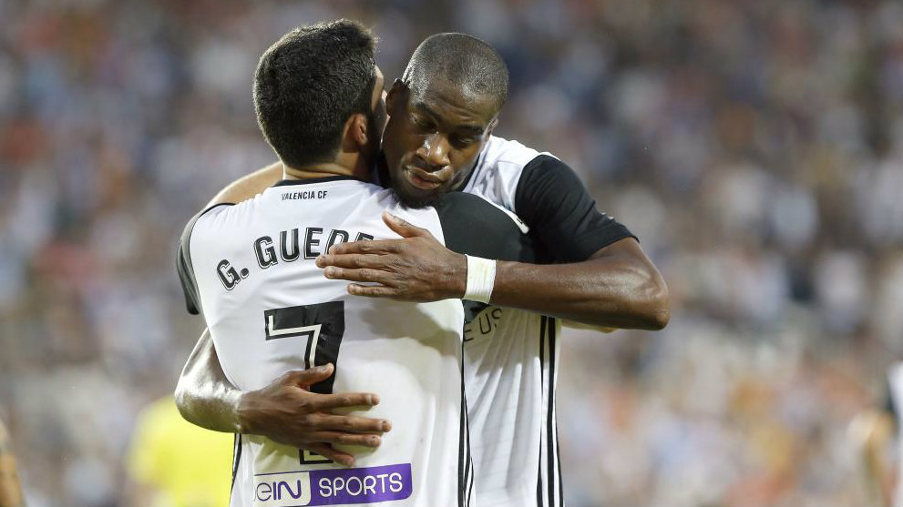 Guedes y Kondogbia se abrazan en un partido de Liga con el Valencia.