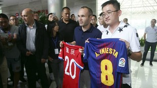 Iniesta posa con una camiseta del Chongqing Dangdai Lifan junto a...