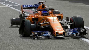 Fernando Alonso, con las dos ruedas derechas destrozadas llegando a...
