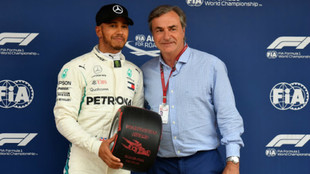 Carlos Sainz, entregando la rueda conmemorativa a Hamilton por la pole