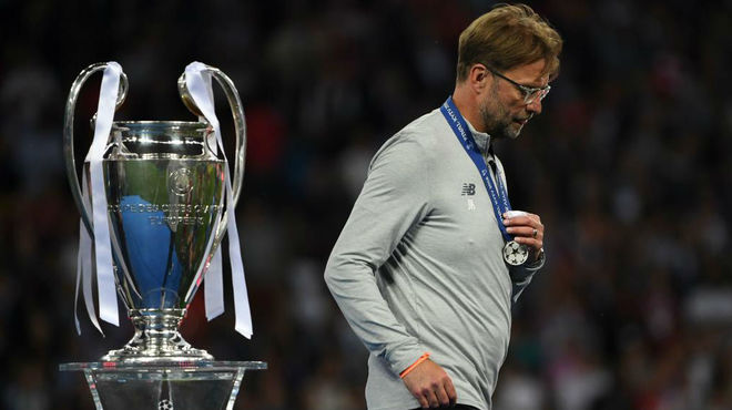 Jurgen Klopp walks past the trophy as he collects his loser&apos;s medal...