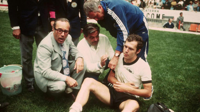 Beckenbauer, con el hombro derecho maltrecho, recibe las atenciones de los asistentes alemanes.