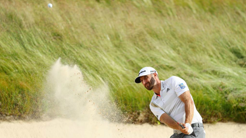Dustin Johnson of the United States plays a shot from a bunker on the...