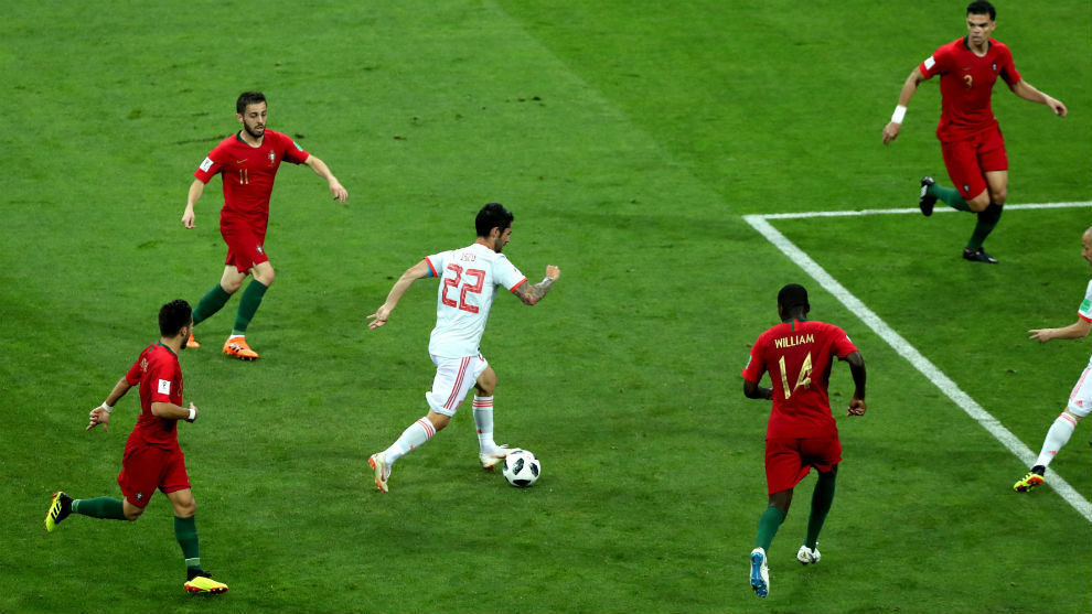 Isco conduce la pelota rodeado de jugadores de Portugal.