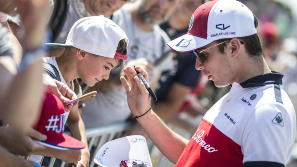 Leclerc firma un autógrafo a un niño.