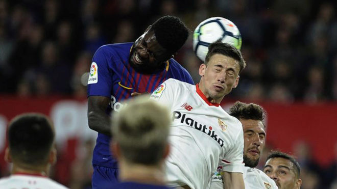 Umtiti jumps for the ball with Sevilla&apos;s defender Clement Lenglet.