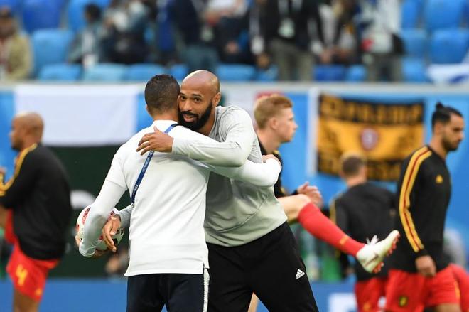 Belgium&apos;s French assistant coach Thierry Henry (R) greets a France...