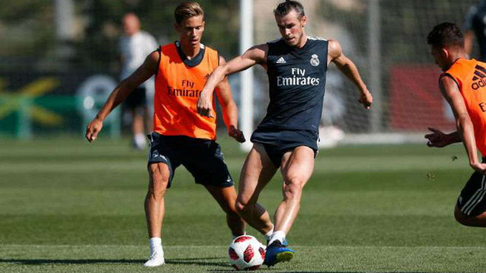 Bale, perseguido por Marcos Llorente, golpea el baln en el...