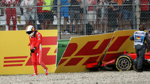 Vettel se aleja cabizbajo de su coche.