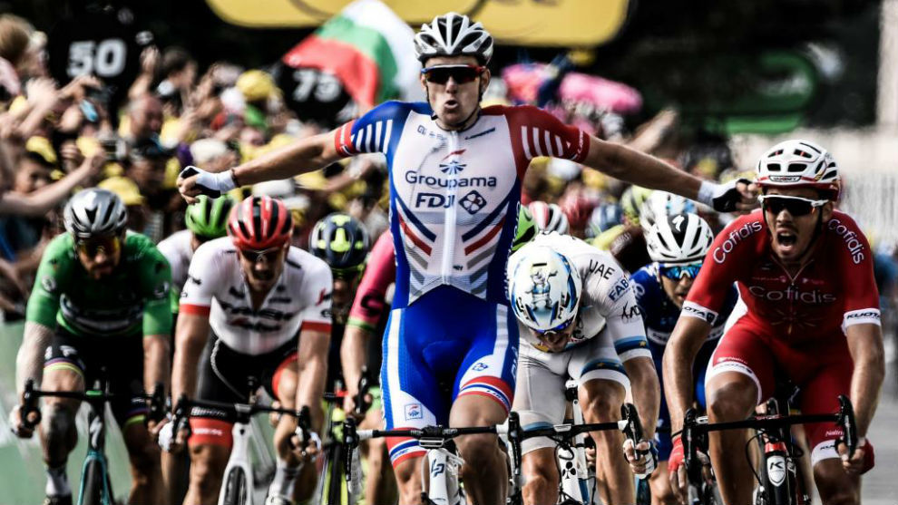 Arnaud Demare celebrates as he crosses the finish line to win the 18th...