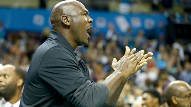 Michael Jordan aplaude durante un partido de sus Charlotte Hornets