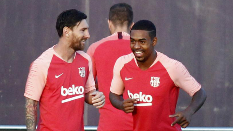 Malcom smiles at training next to Leo Messi.