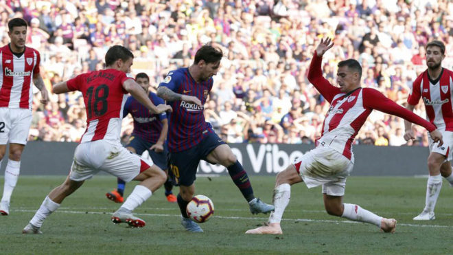 Lionel Messi vies with Oscar De Marcos and Dani Garcia