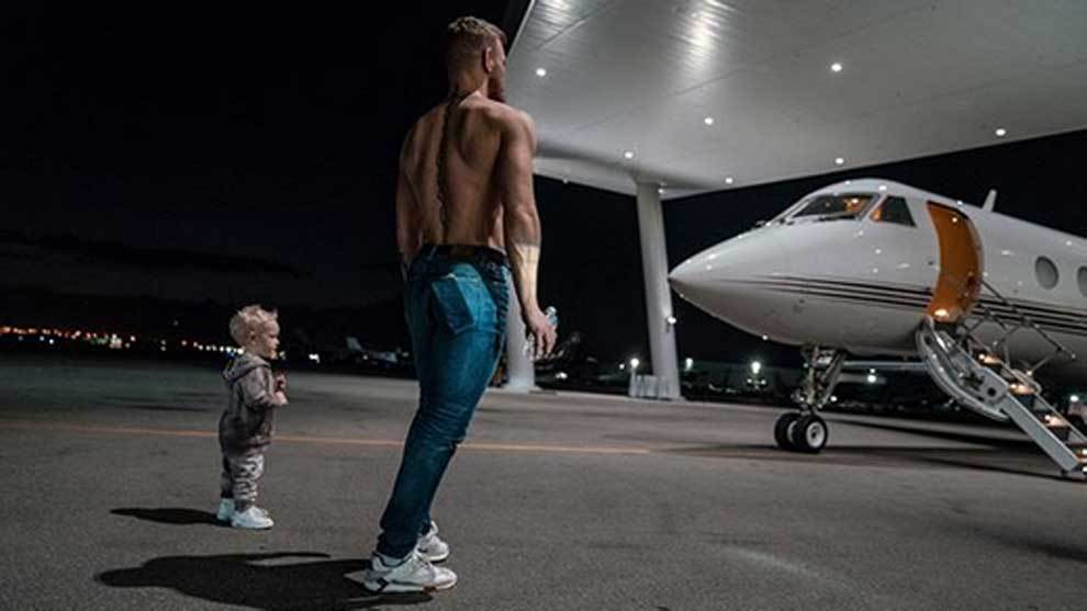 Conor McGregor posando sin camiseta junto a su hijo Conor Jnr delante...