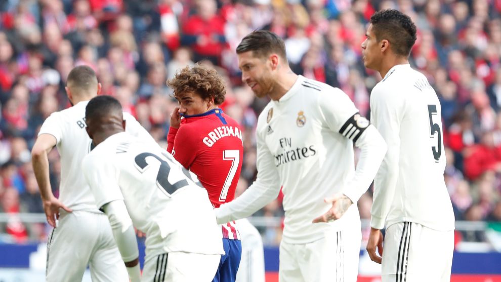 Antoine Griezmann rodeado de jugadores del Real Madrid