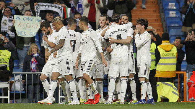 Karim Benzema celebrates with teammates after scoring his team&apos;s third...