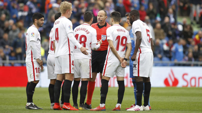 The Sevilla players protest the red card for Sergio Escudero.
