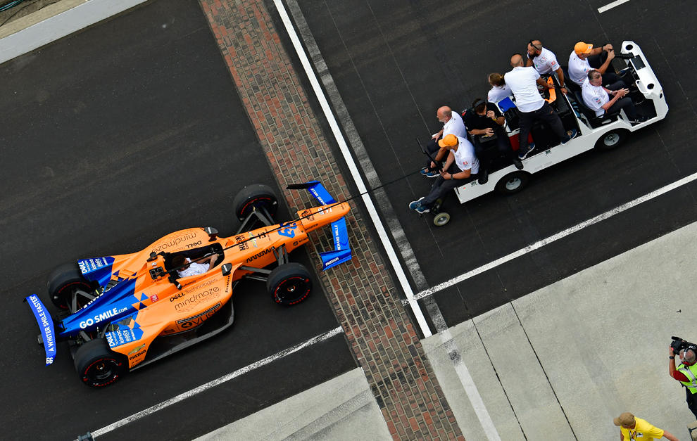 El McLaren #66, remolcado por miembros del equipo.