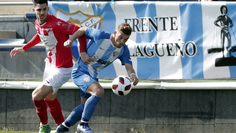 Un futbolista del Atltico Malagueo luchando por el baln.