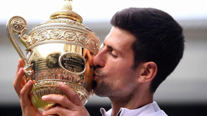 Novak Djokovic besa el trofeo de ganador de Wimbledon 2019.