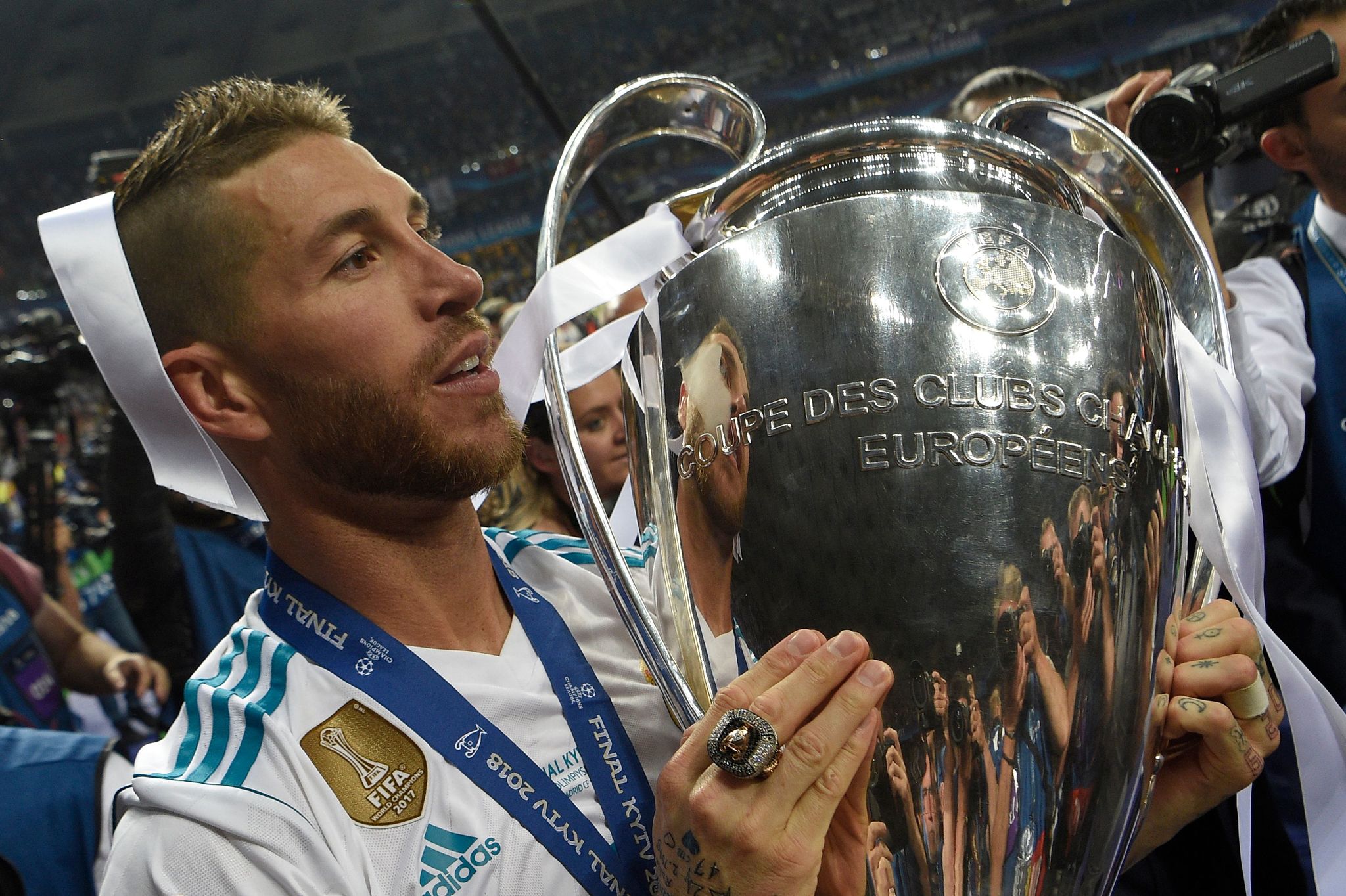 Real Madrids Spanish defender Sergio <HIT>Ramos</HIT> holds the trophy after winning the UEFA <HIT>Champions</HIT> League final football match between Liverpool and Real Madrid at the Olympic Stadium in Kiev, Ukraine on May 26, 2018. Real Madrid defeated Liverpool 3-1. / AFP PHOTO / LLUIS GENE