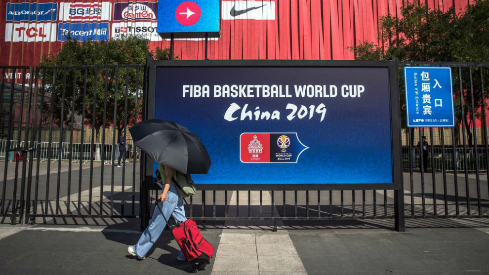 Una persona pasa ante un cartel del Mundial de baloncesto.