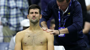Novak Djokovic es atendido del hombro antes de retirarse del US Open.