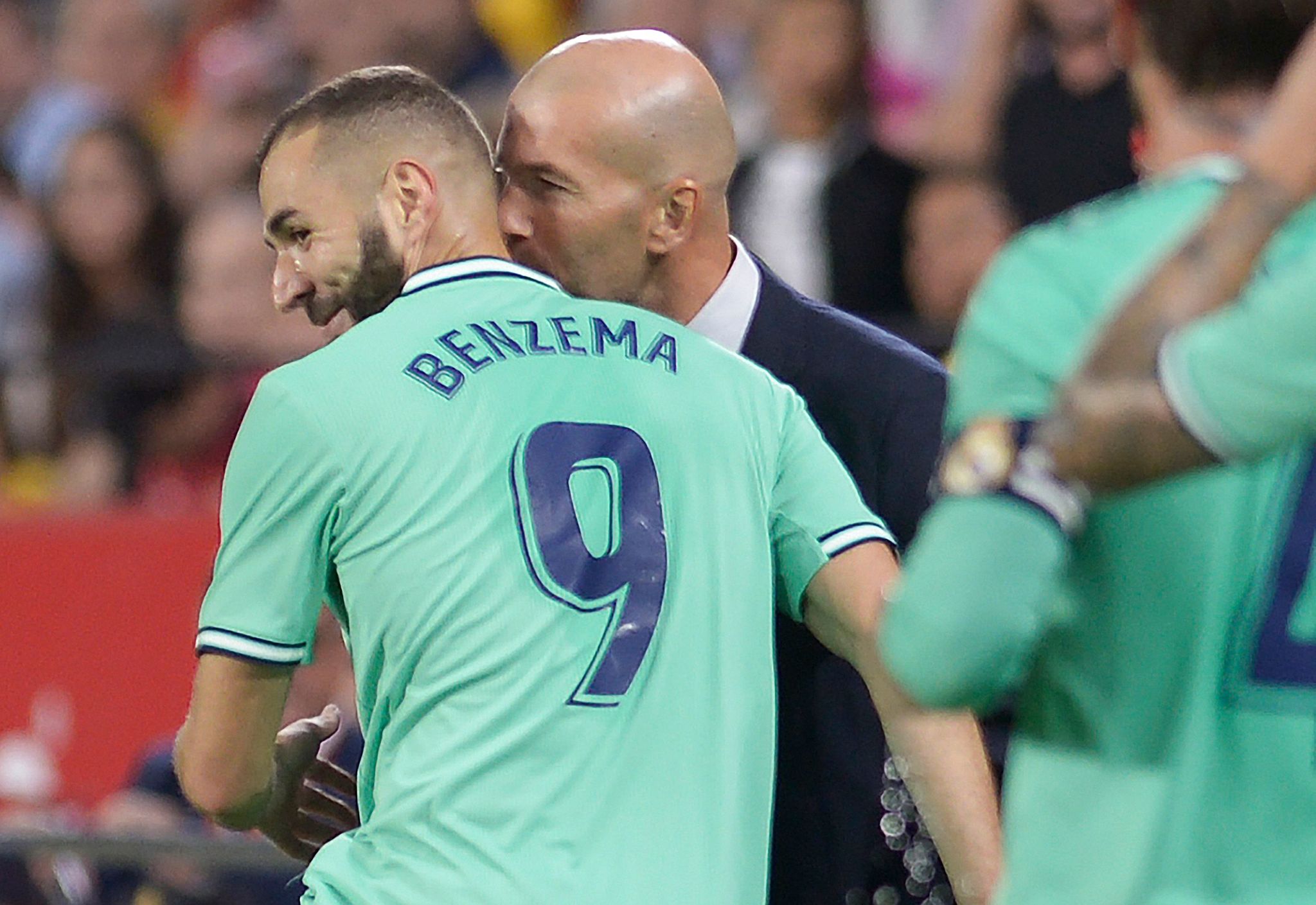 Real Madrids French coach Zinedine Zidane (R) congratulates Real Madrids French forward Karim <HIT>Benzema</HIT> for his goal during the Spanish league football match between Sevilla FC and Real Madrid CF at the Ramon Sanchez Pizjuan stadium in Seville on September 22, 2019. (Photo by CRISTINA QUICLER / AFP)