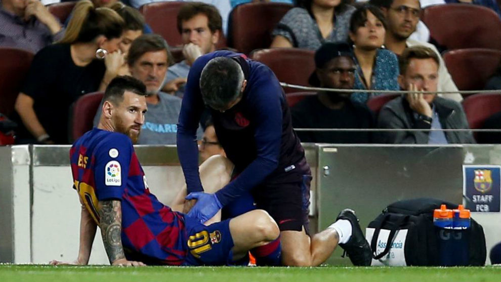 Messi es atendido por el mdico y el fisioterapeuta del club.