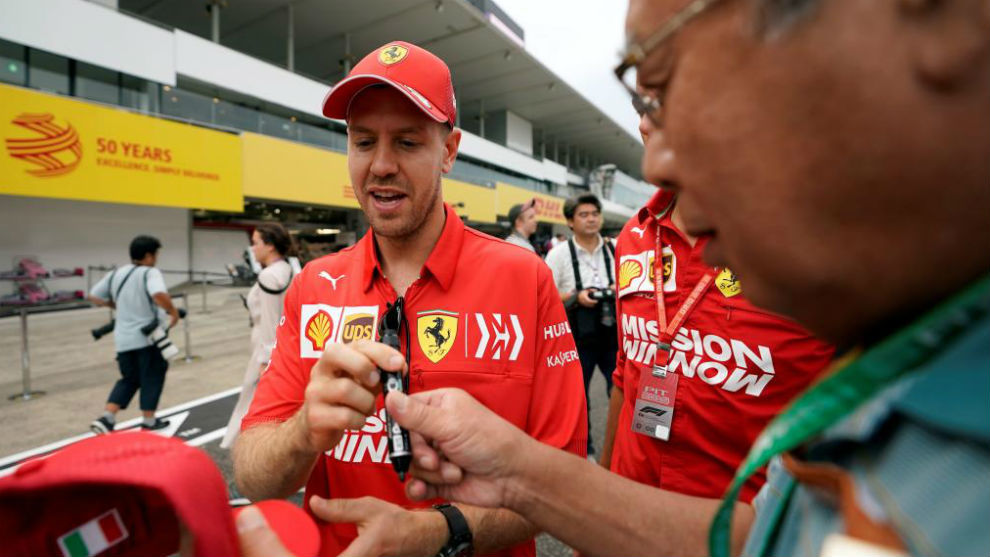 Vettel firma un autgrafo a un aficionado japons en Suzuka.