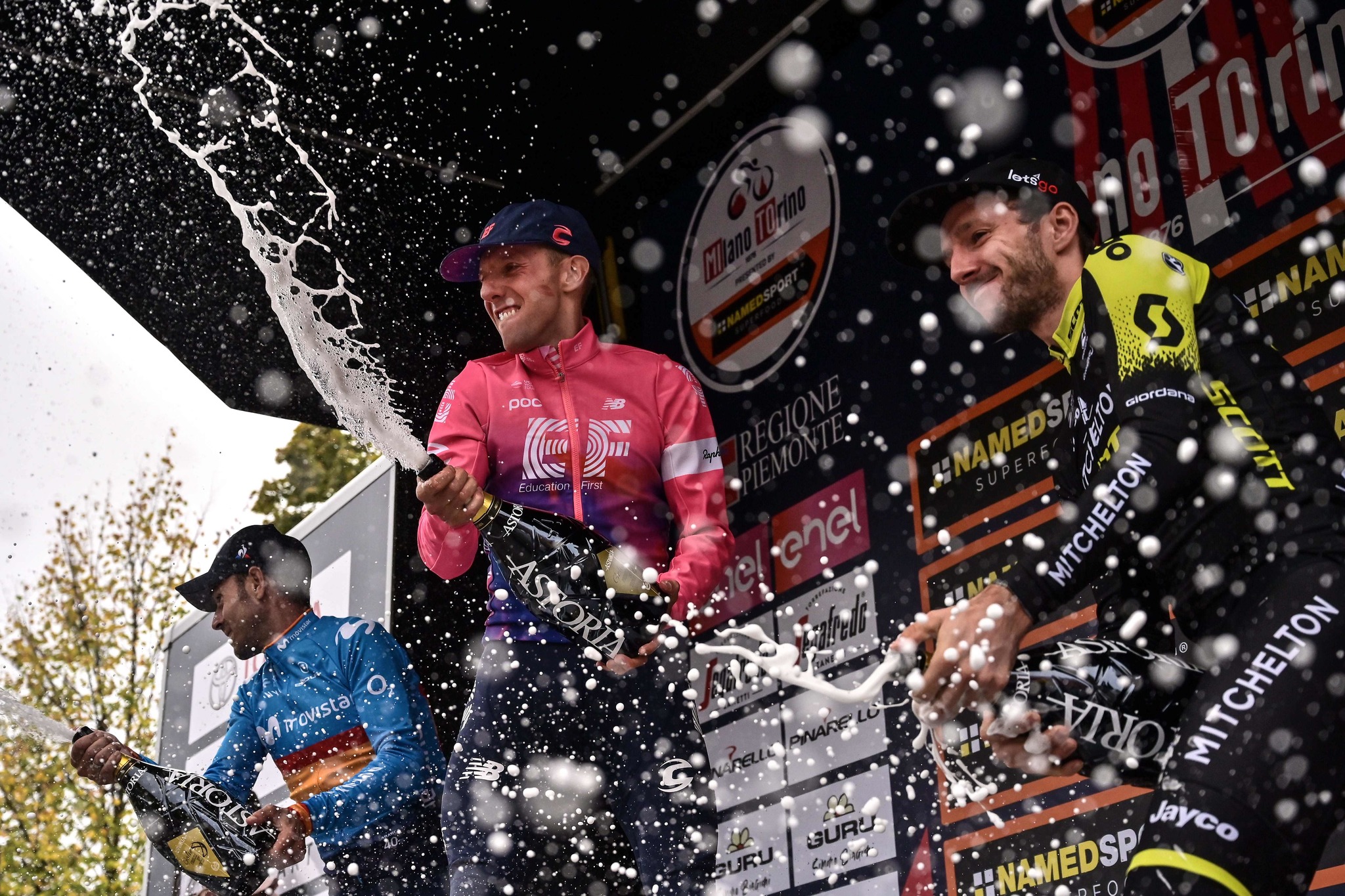 (FromL) Second-placed Spains Alejandro <HIT>Valverde</HIT> (Movistar), race winner Canadas Michael Woods (EF Education First) and third-placed Britains Adam Yates (Mitchelton-Scott) spray champagne as they celebrate on the podium after the 100th edition of the one-day classic cycling race Milan - Torino on October 9, 2019 between Magenta, west of Milan and Superga, east of Torino. (Photo by Marco BERTORELLO / AFP)
