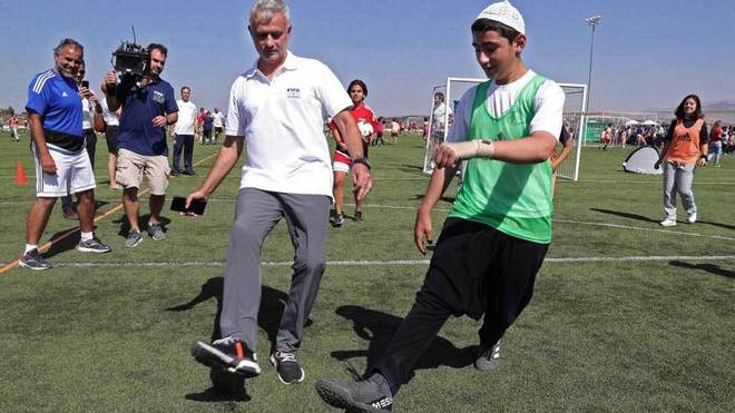 Mourinho juega juega con uno de los escolares durante la ceremonia del...
