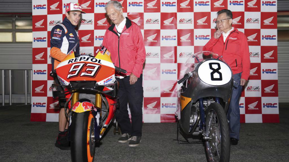 Márquez enseña su moto a Jim Redman.