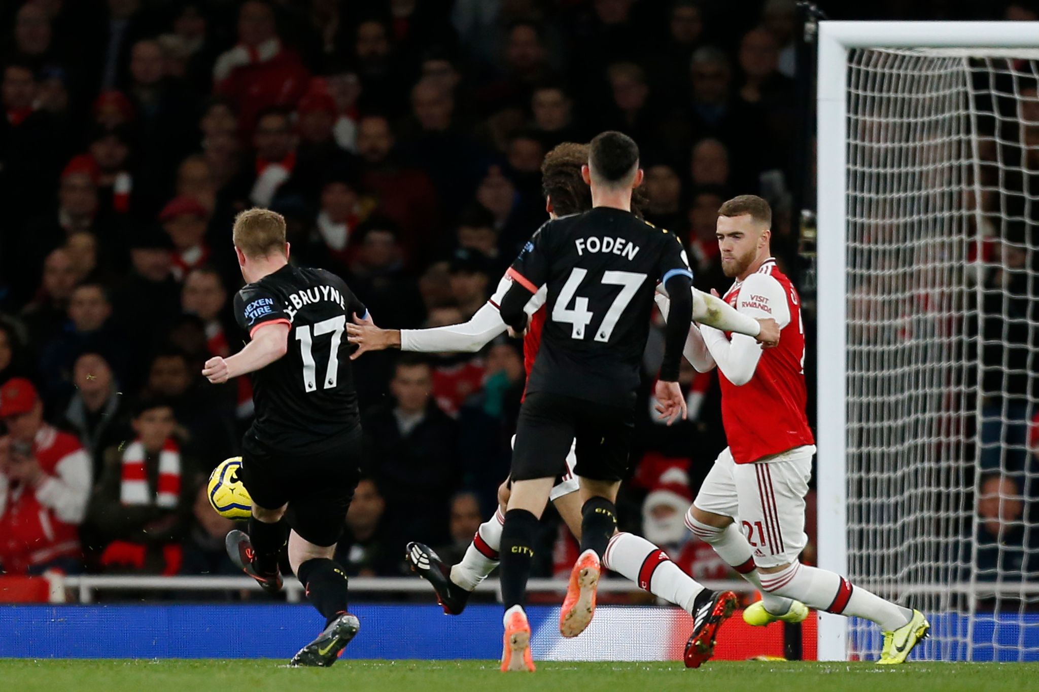 Manchester Citys Belgian midfielder Kevin De <HIT>Bruyne</HIT> (L) shoots to score their third goal during the English Premier League football match between Arsenal and Manchester City at the Emirates Stadium in London on December 15, 2019. (Photo by Ian KINGTON / IKIMAGES / AFP) / RESTRICTED TO EDITORIAL USE. No use with unauthorized audio, video, data, fixture lists, club/league logos or live services. Online in-match use limited to 45 images, no video emulation. No use in betting, games or single club/league/player publications