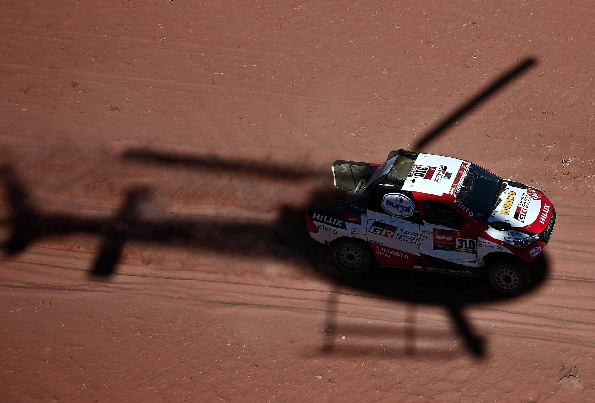 A helicopter flies as Toyotas Spanish drivers Fernando <HIT>Alonso</HIT> and co-driver Marc Coma compete during the Stage 3 of the Dakar 2020 around Neom, Saudi Arabia, on January 7, 2020. (Photo by FRANCK FIFE / AFP)