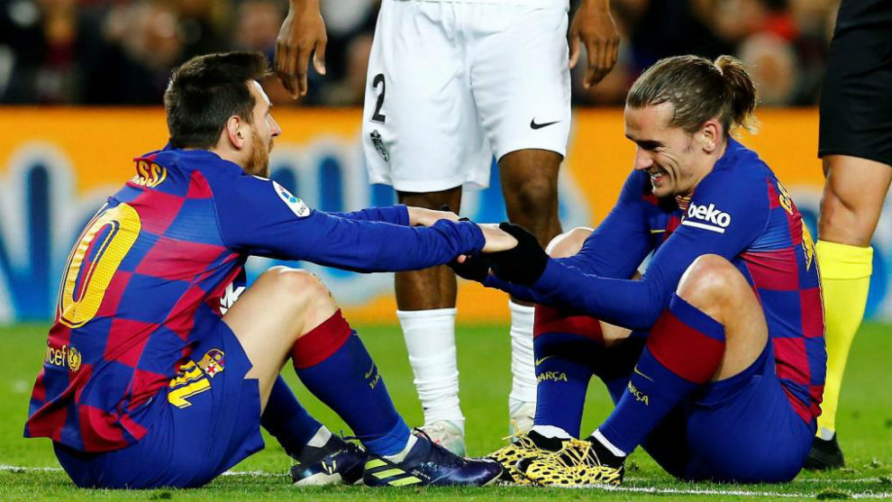 Messi y Griezmann se ayudan a levantar.