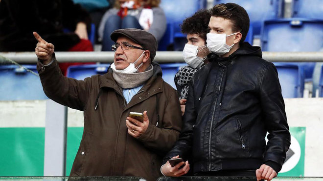 Two Roma fans wearing face masks at the Stadio Olimpico