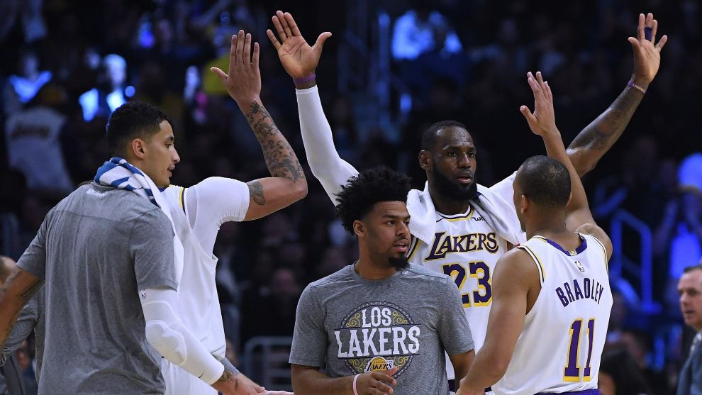 Varios jugadores de los Lakers se chocan las manos durante un partido.