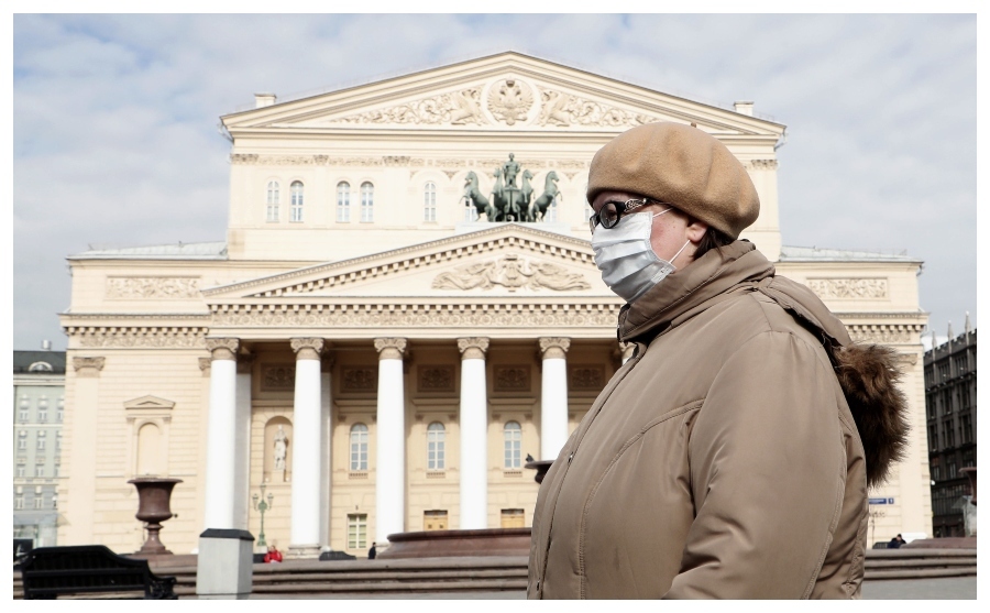 Una moscovita pasa ante el Boslhoi protegida con una mascarilla.