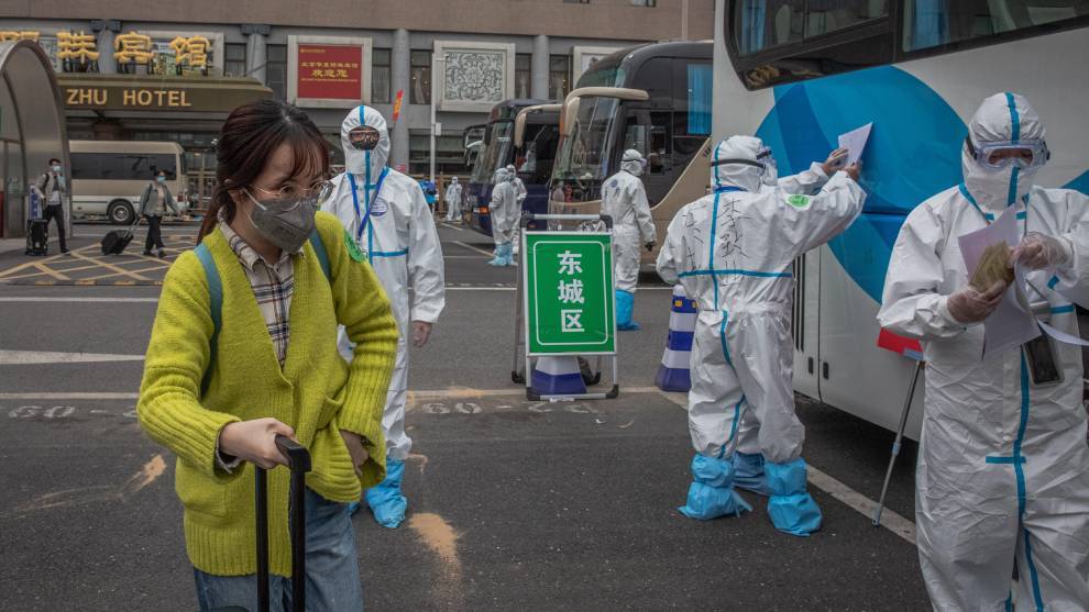 Un autobs procedente de Wuhan y sus pasajeros son desinfectados al...