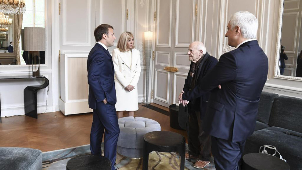 Macron charla con Christian Chenay junto a la primera dama.