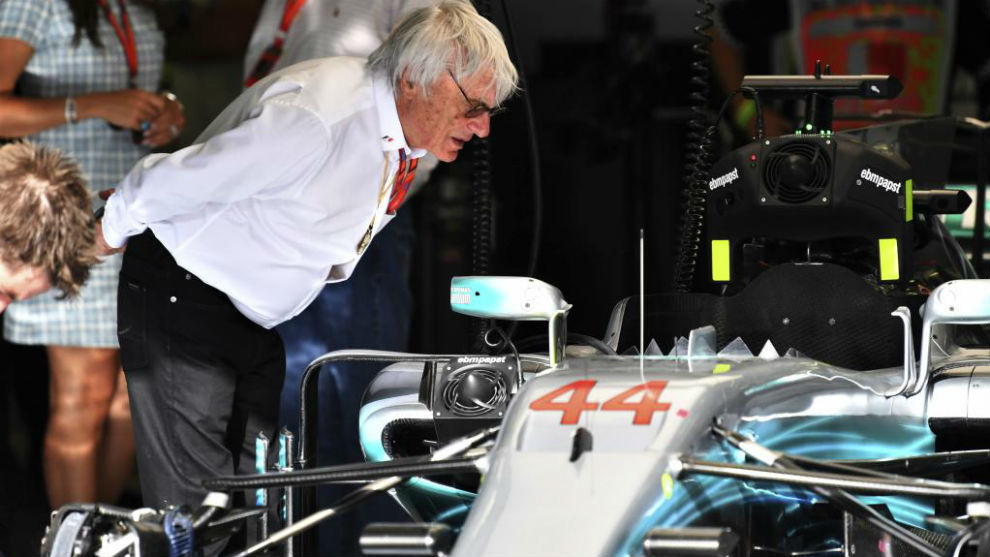 Ecclestone mira el habitculo del Mercedes de Hamilton.
