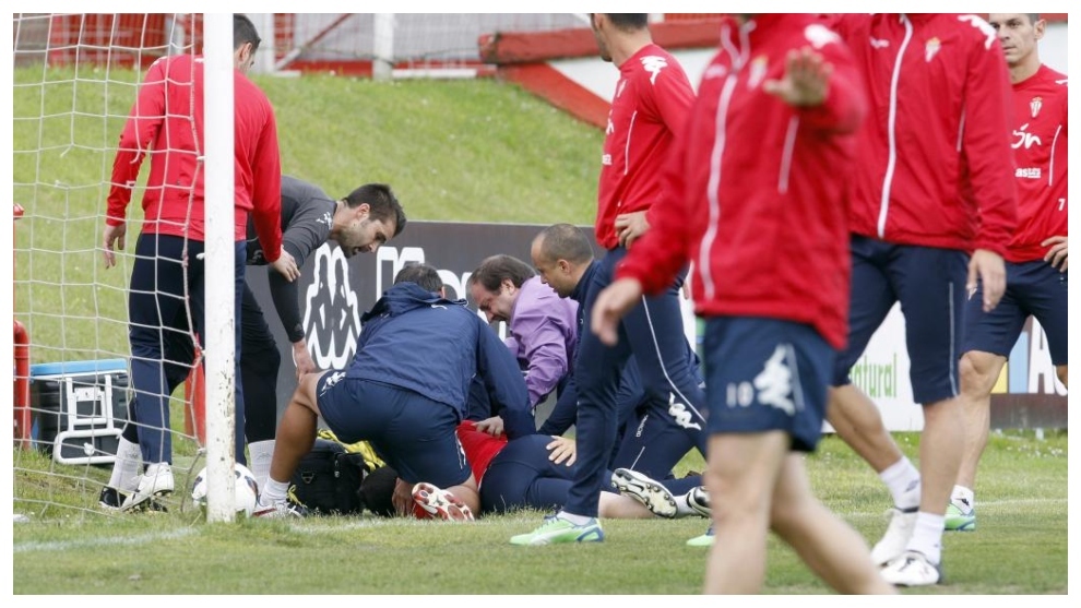 El doctor Revuelta atiende a un jugador del Sporting durante un...