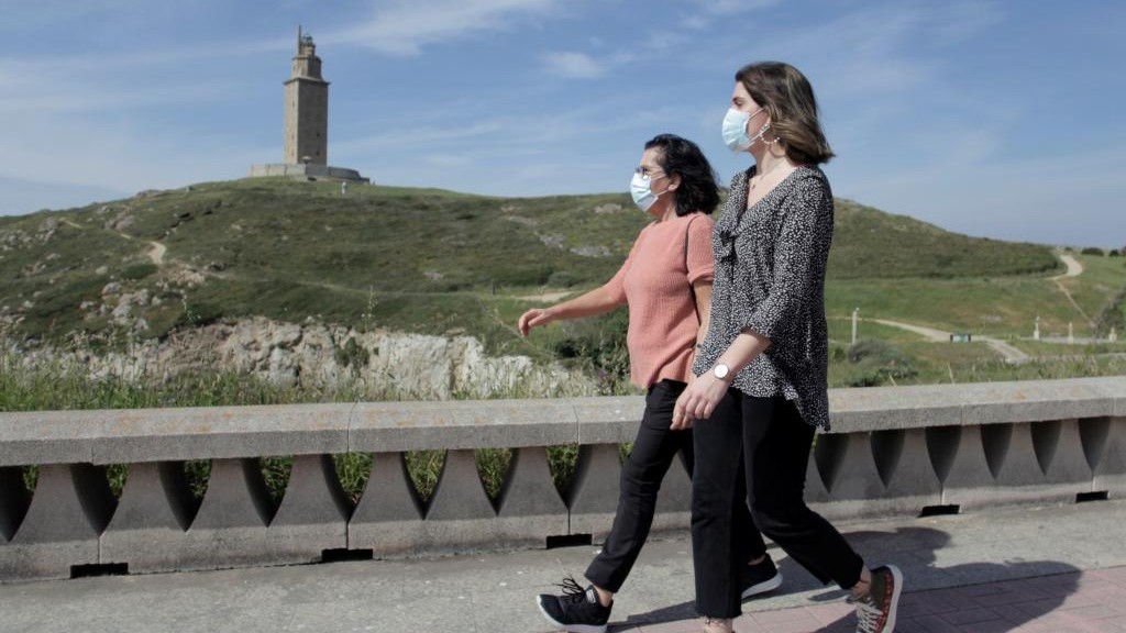 Dos mujeres con mascarilla caminan este jueves por el entorno de la Torre de Hrcules en La Corua.